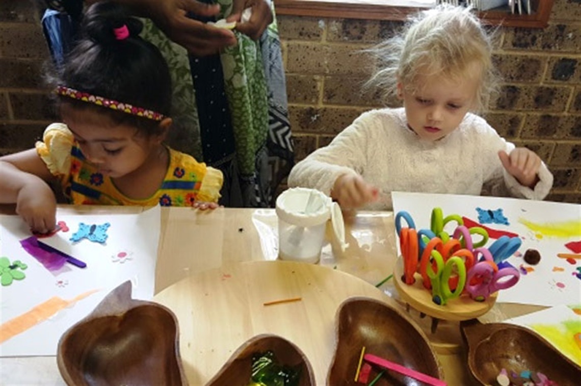 Children working with paints and crayons at table