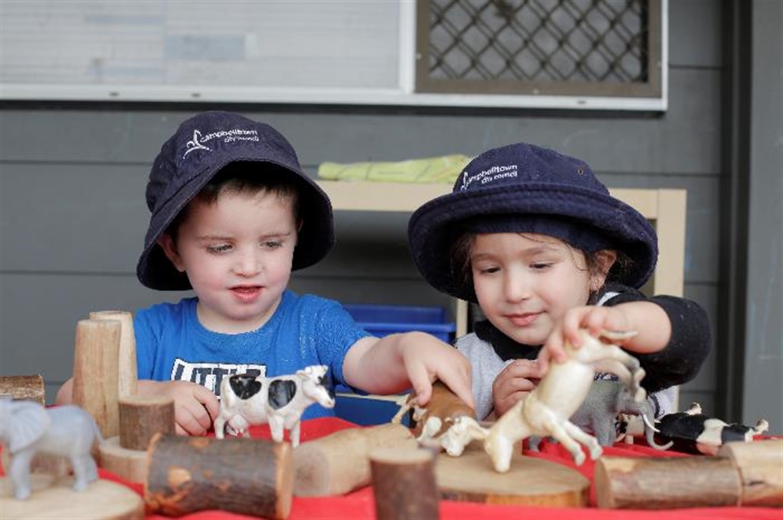 Two children playing with toy animals