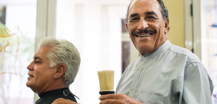 Barber holding brush with happy customer