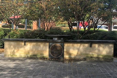 It stands in a courtyard marked with a fountain, and name plaques