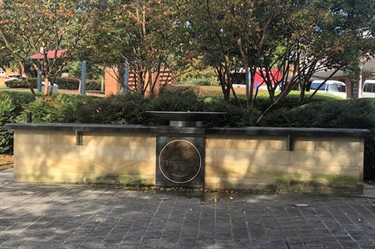 It stands in a courtyard marked with a fountain, and name plaques