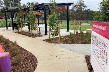 Pathways and landscaped areas leading to picnic shelters with seats and tables
