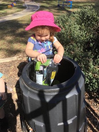 Child filling up the recycling bin