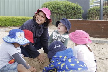 Kids and educator in sandpit