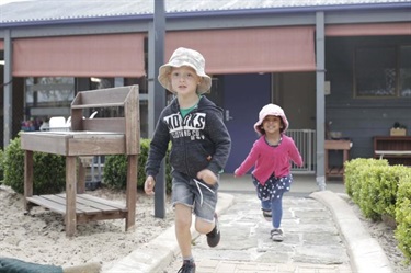 Two children running around the outdoor space