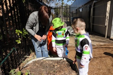 Educator and children in garden