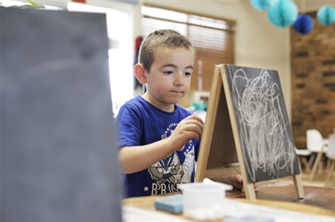 Boy drawing on chalkboard