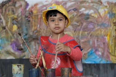 Child ready to paint with paintbrush