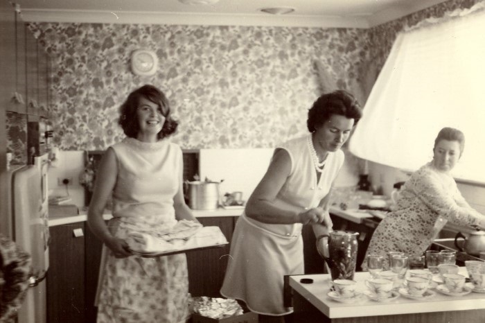 Three women cooking in a 1970s style kitchen kitchen