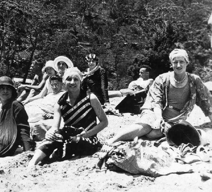 Old photograph of young people on the bank of a river