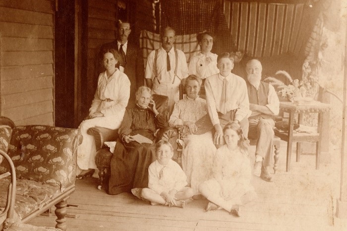 An old sepia photograph of a large group of fmaily and friends 