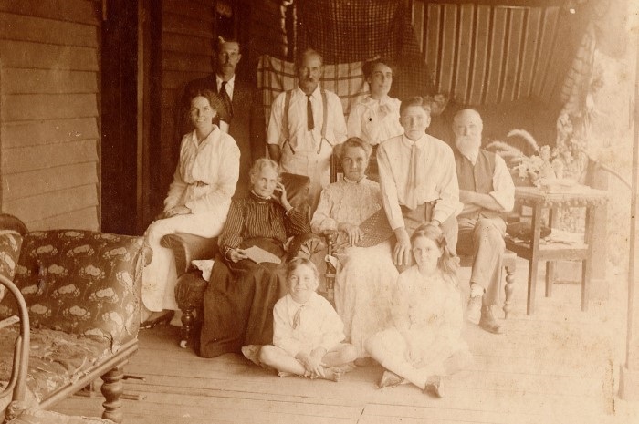 An old sepia photograph of a large group of fmaily and friends