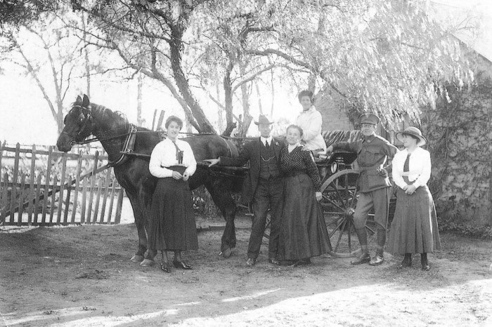 A family portrait in front of a horse and cart 