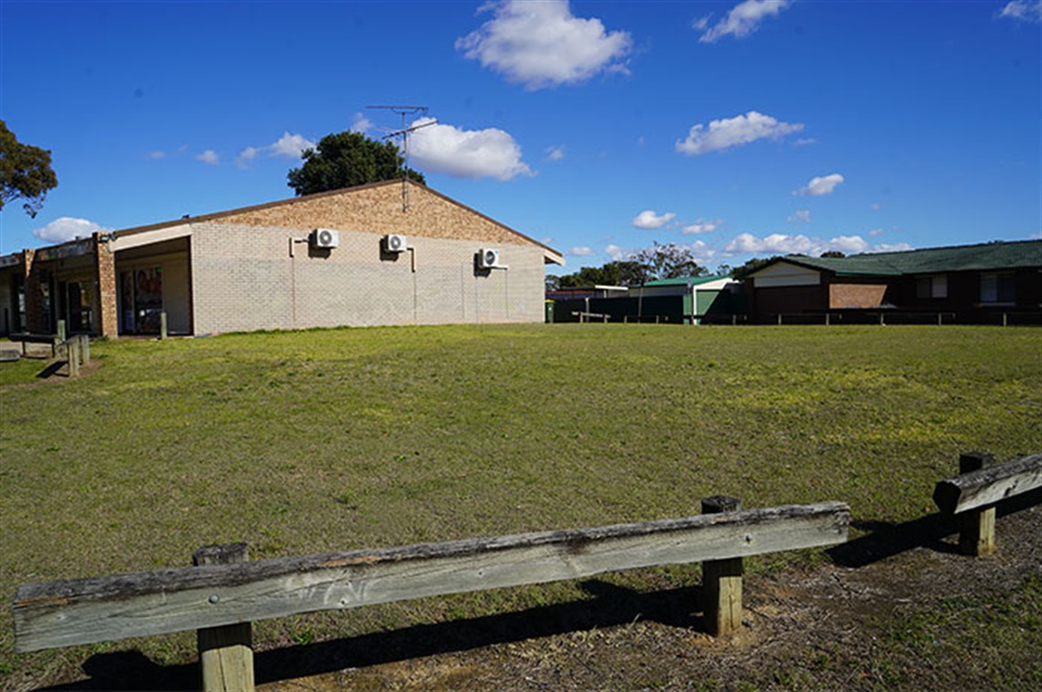 Bradfield Reserve - grassed area with copper log fence in foreground and building in background