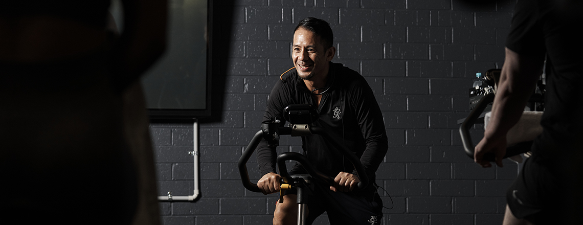 A man riding a spin bike in a fitness class