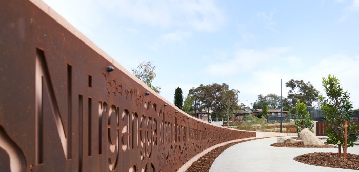 Billabong entry pathway with welcome sign featuring Aboriginal artwork and name