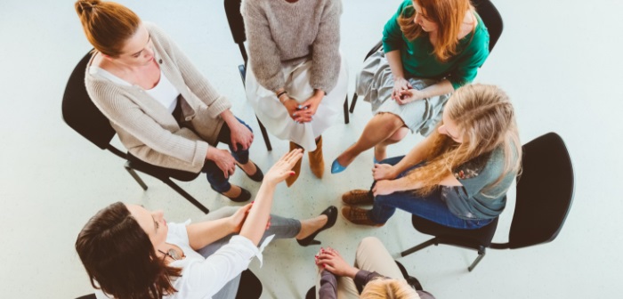 A group of 6 females sitting on chairs arranged in a circle