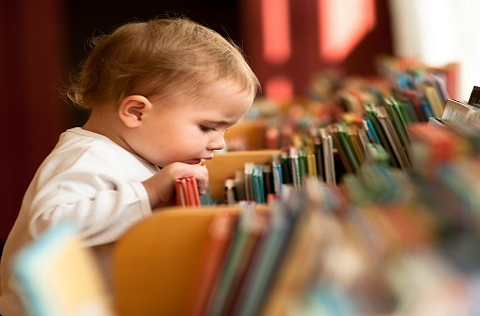 Baby looking at books at library
