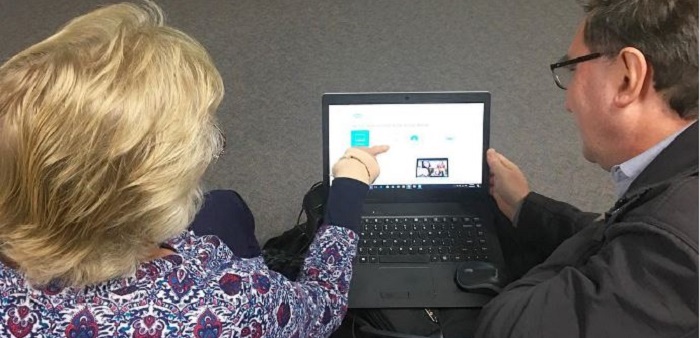 Staff teaching woman about technology on a laptop