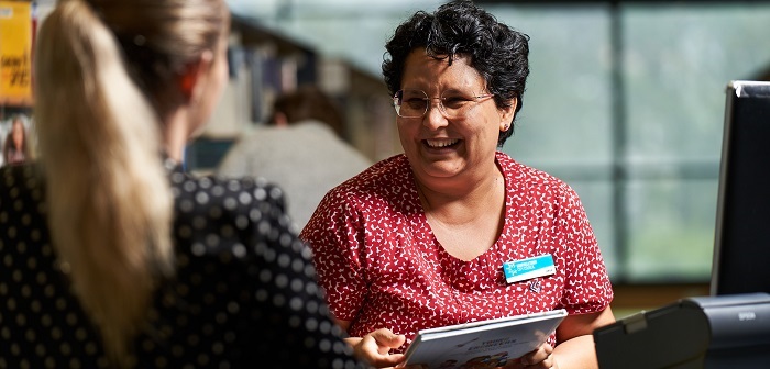 Female staff member serving member of the public smiling