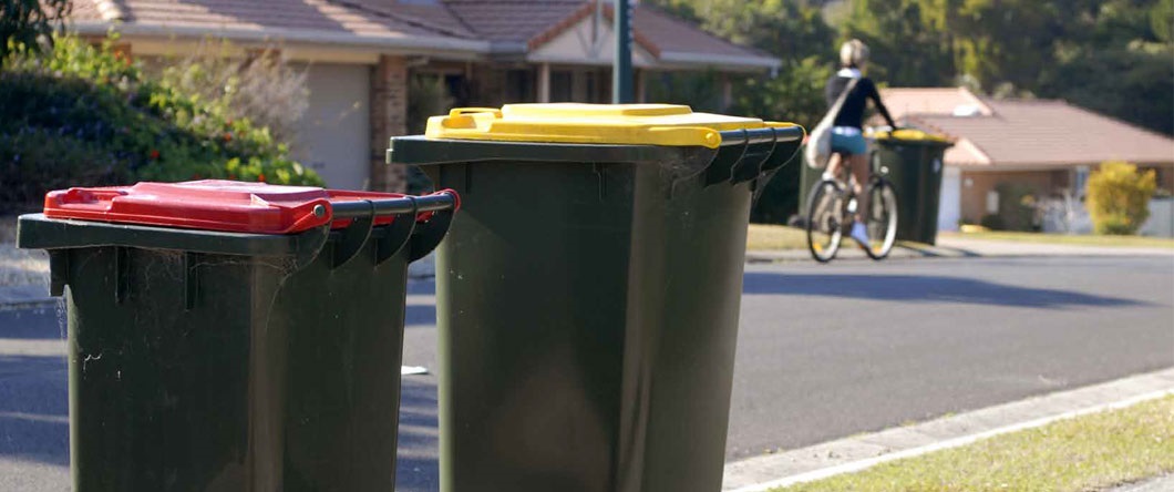 Red lid and yellow lid bin on a kerbside