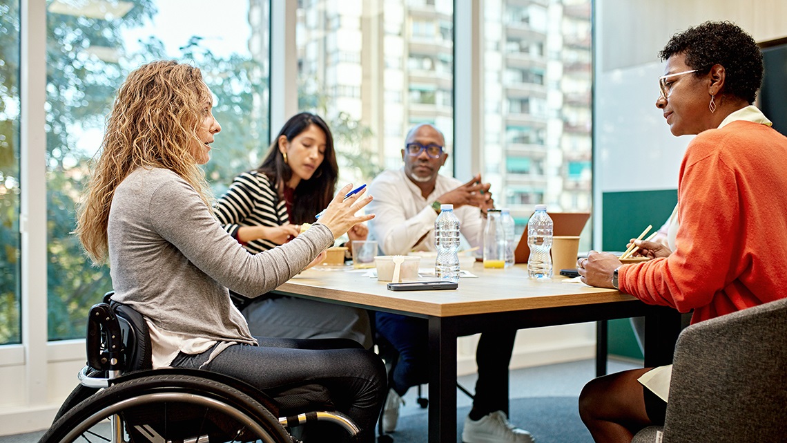 A group of people sitting around a table, discussing ideas.