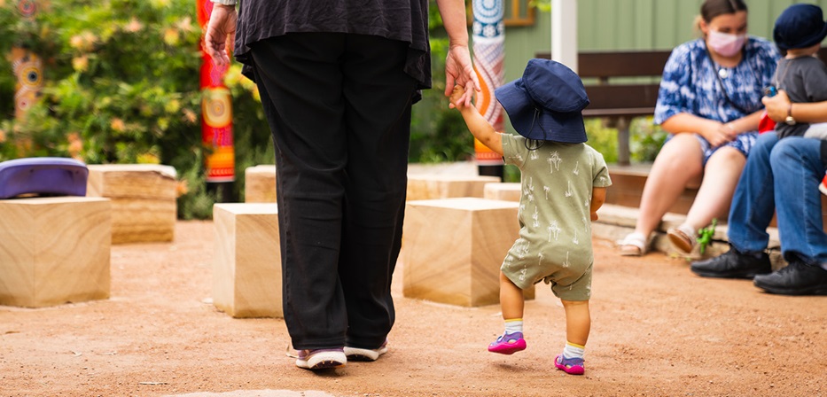 Child walking with educator